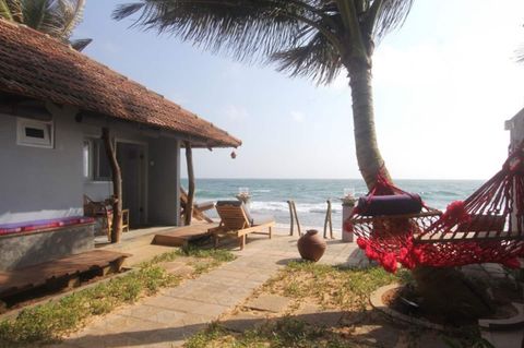 Palms and garden shade between the rooms and the beach at EKA Beach