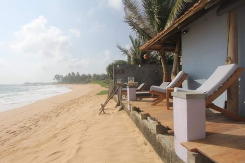 Low tide on the golden sand in front of EKA Beach, Talpe, with palms and loungers