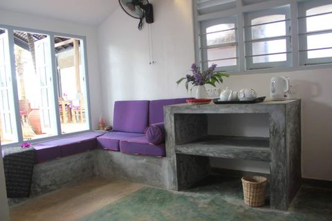 A seating corner with a sofa beside a window in a room at EKA Beach